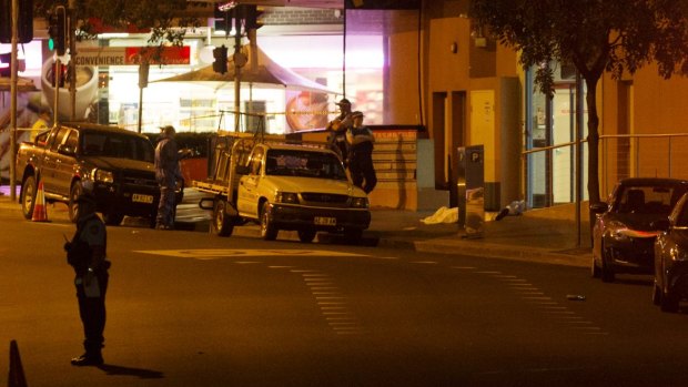A body lies on the ground after the shooting outside the NSW Police Headquarters.