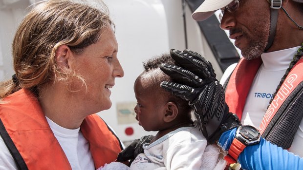 Marcella Kraay, project coordinator for the MSF, holding a rescued child on the Aquarius.