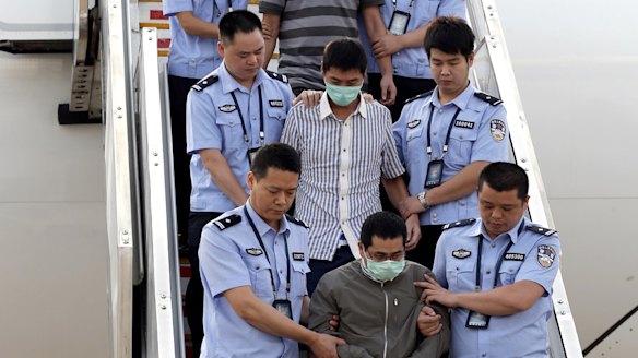 Six fugitives accused of economic crimes are taken back to China under escort from Indonesia in June 2015 as part of Operations Fox Hunt and Skynet.