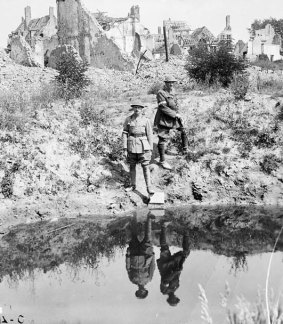 Soldiers at Ypres reflected in a shell crater lake.