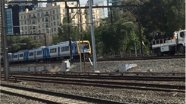 A train comes dangerously close to a maintenance vehicle between Flinders and Richmond stations on Saturday.