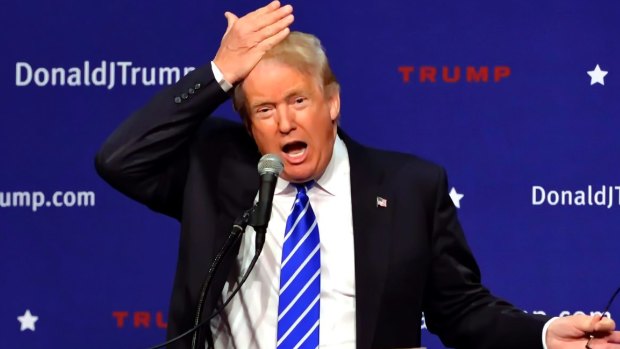 Trump pulls his hair back to show that it is not a toupee in 2015.