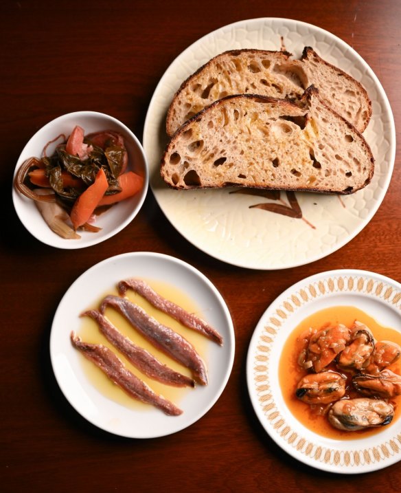 Clockwise from top right: House-baked sourdough bread with mussels
escabeche, anchovies and pickles.