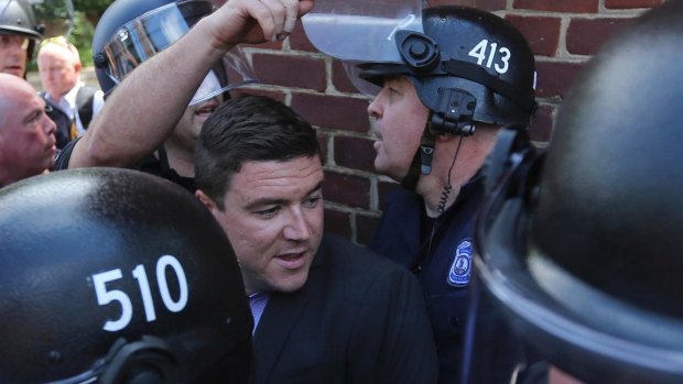 Unite the Right rally organiser Jason Kessler is escorted by police after his press conference was disrupted by protesters in August.