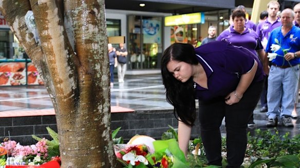 Chaplain Sarah Bennett lays flowers for Cole Miller.