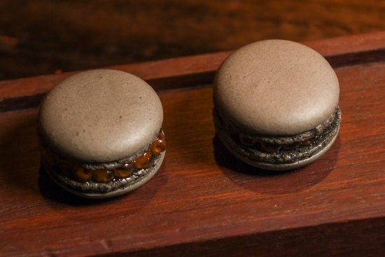 Signature black garlic macarons filled with salmon roe are available in the restaurant and its adjacent bar.