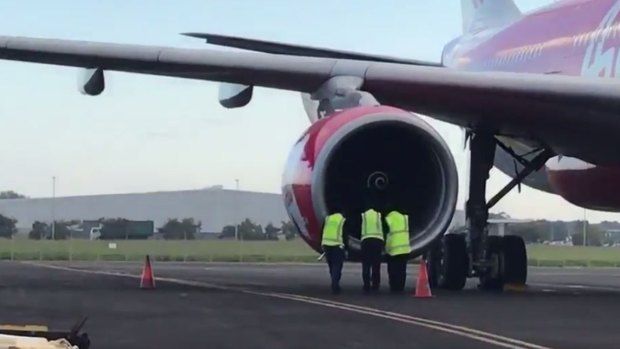 AMSA officers inspect an Air Asia X jet forced to turn back on a flight from the Gold Coast.