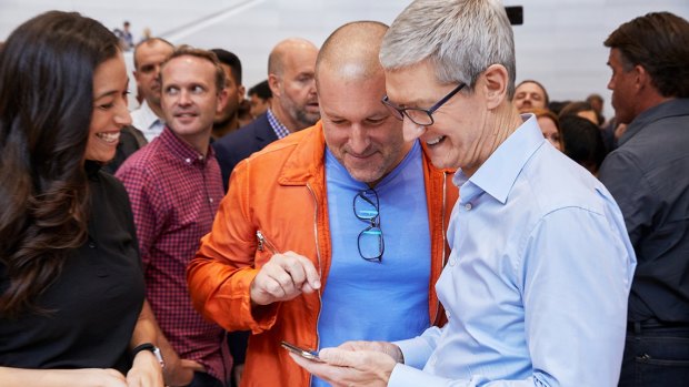 Apple's Tim Cook and Jony Ive look at the new iPhone X in the hands on area.