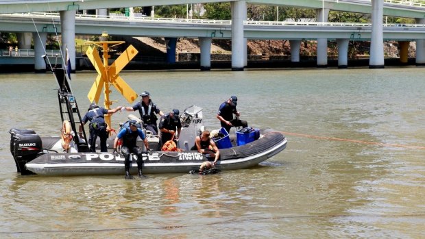 Police investigate bubbles in the Brisbane River near QPAC during G20.