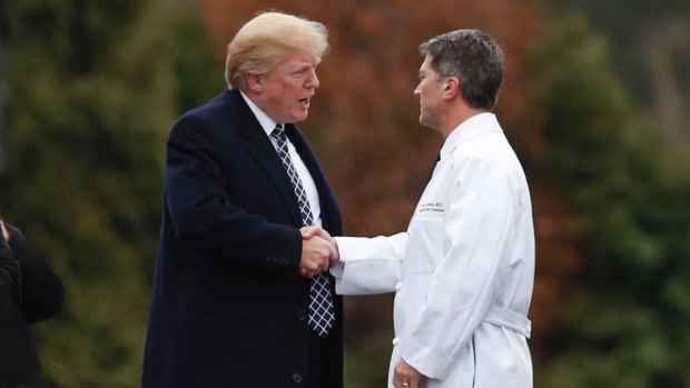 President Donald Trump shakes hands with White House physician Dr. Ronny Jackson after his first medical check-up as president.