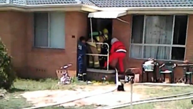Firefighter Santa Nick Carey and his team rescue a man from a house fire in Maitland during their annual lolly run.