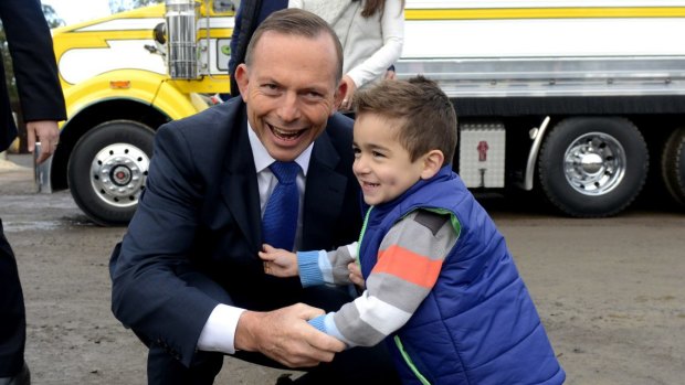 Tony Abbott greets a child during a visit Daisy's Garden Supplies in Ringwood.