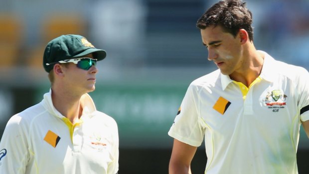 Steve Smith talks to Mitchell Starc as the left-arm paceman walks back to his bowling mark.