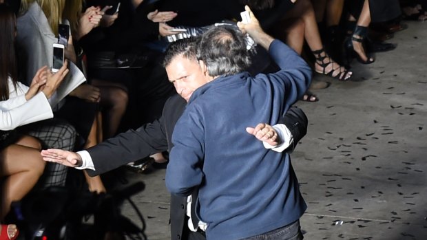 Furious neighbour storms the show: Security intervene as a man attempts to get on the catwalk at Mercedes-Benz Fashion Week.