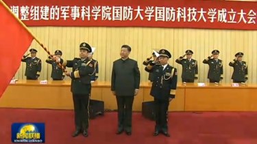 General Yang stands next to Chinese President Xi Jinping holding the PLA flag.