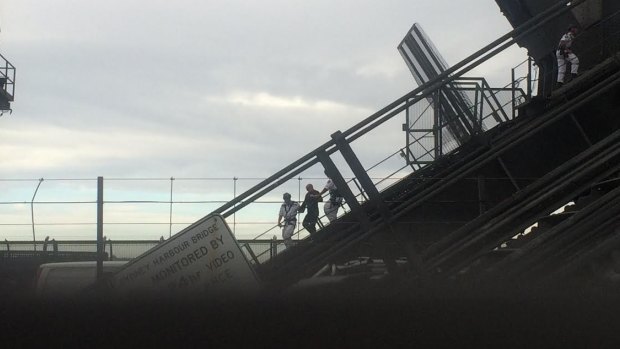 NSW Police Rescue officers escort Adrian Karibian off the Sydney Harbour Bridge.