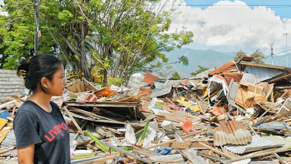 Ayu looks at the ruble left byt he tsunami at Talise, Palu.