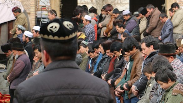 Uighur Muslims attend Friday prayers at the central mosque in Hotan, Xinjiang, where they are under constant state surveillance.