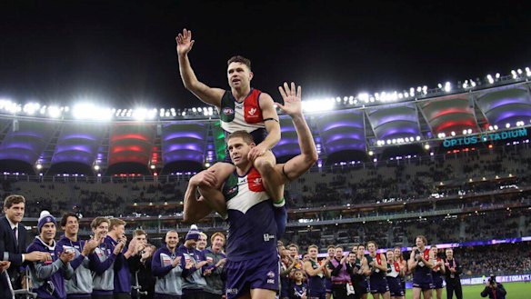 Aaron Sandilands and Hayden Ballantyne are clapped off the field after their last game in front of the Fremantle Dockers faithful at Optus Stadium.