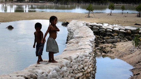 A sea wall in the Kiribati village of Tebunginako at low tide. The formerly freshwater lagoon is inundated with sea water due to rising seas and erosion.