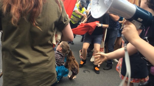 A student fell to the ground as protesters scrambled during a protest march on Sydney's Broadway on Wednesday.