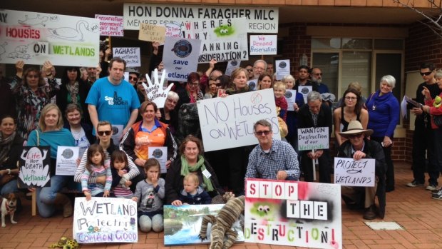 Protesters gather outside Planning Minister Donna Faragher's office.