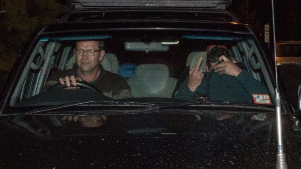 Mark Tromp, pictured right, is driven from the Wangaratta police station on Saturday night.