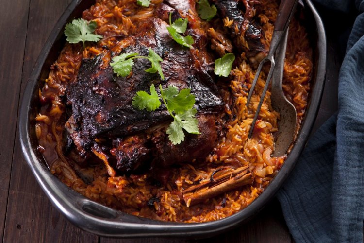 Greek tomato-baked lamb with orzo. Jill Dupleix recipes for Epicure and Good Living. Photographed by Marina Oliphant. Food preparation and styling by Caroline Velik. Teatowel from Manon bis, Mud bowl from Essential Ingredient, green bottle from Safari Living, MUST CREDIT. Photographed March 22, 2012. The Age Newspaper and The Sydney Morning Herald.