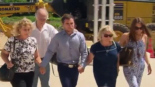 Thomas Keating (centre) arriving at Phuket police station with members of his family, and the family of his late girlfriend Emily Collie.