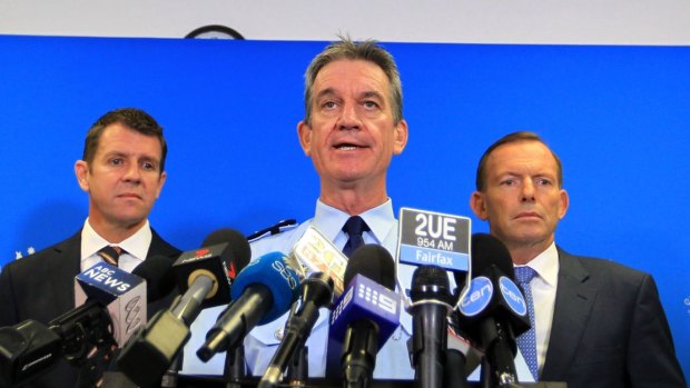 NSW Police Commissioner Andrew Scipione (centre), flanked by NSW Premier Mike Baird and Prime Minister Tony Abbott, has been criticised for failing to resolve the scandal. 