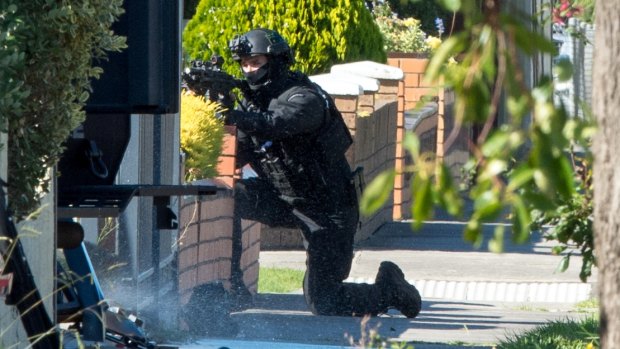 An armed officer takes up position outside the St Albans house.