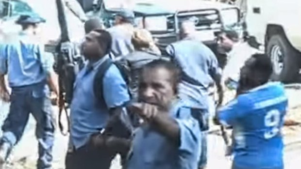 Papua New Guinea police leading Dame Carol Kidu away.