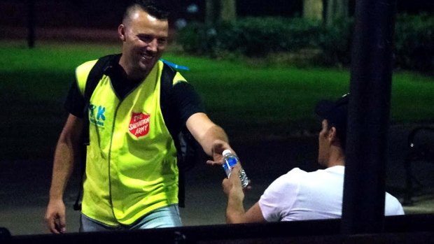 Take Kare Ambassador coordinator Nate Brown offers a bottle of water to a late-night reveller.