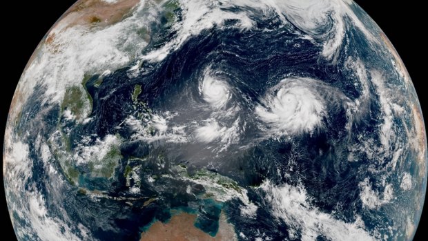 Twin typhoons spin in the western Pacific, far to Australia's north.