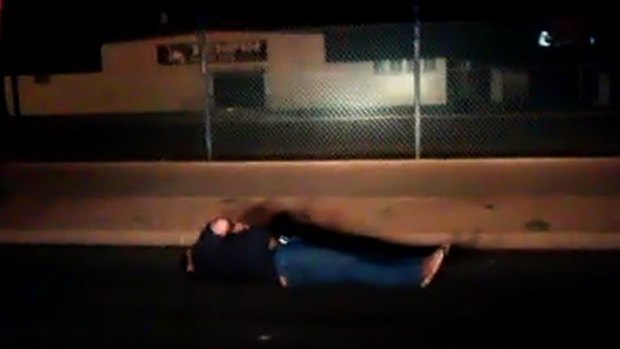 The man lies on the ground after being tasered.