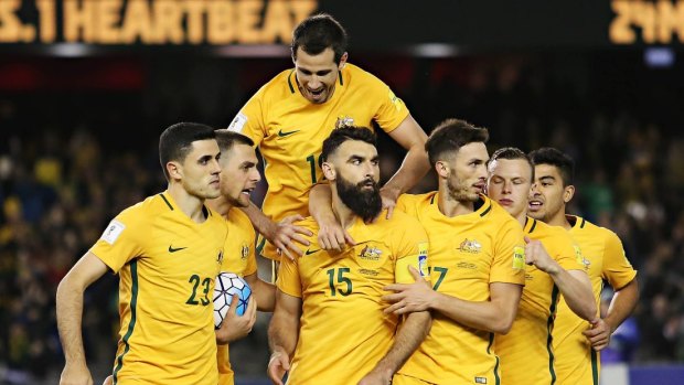 MELBOURNE, AUSTRALIA - OCTOBER 11: Socceroos players celebrate after captain Mile Jedinak converted a penalty to level the score at 1-1 during the 2018 FIFA World Cup qualifier between Australia and Japan.
