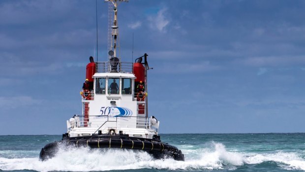 One of the flotilla of tugboats speeds toward its next task.