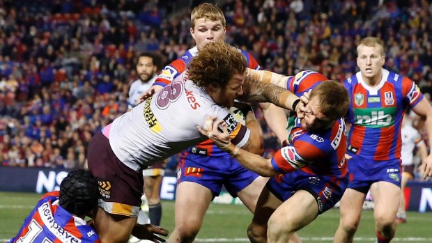 Muscling up: Korbin Sims pushes past the Knights defence to score for the Broncos.