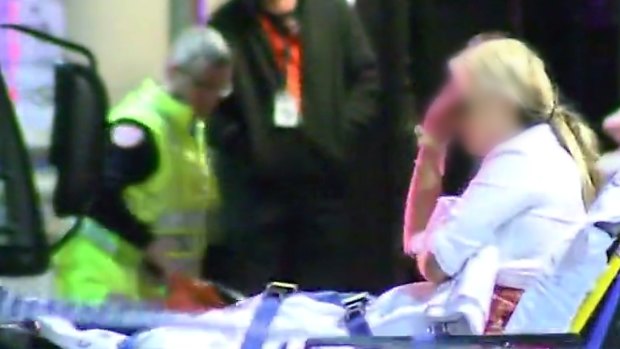 Paramedics help a woman after the Inflation nightclub shooting.