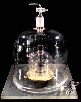 A copy of the International Prototype of the kilogram inside three glass bells in Sevre, France.