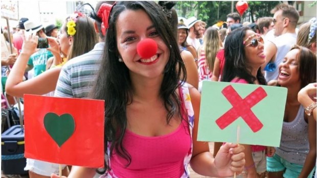 Luiza Rocha, 22, holds up placards with symbols used on the hook-up app Tinder at a Tinder-themed street party in Rio de Janeiro in February.