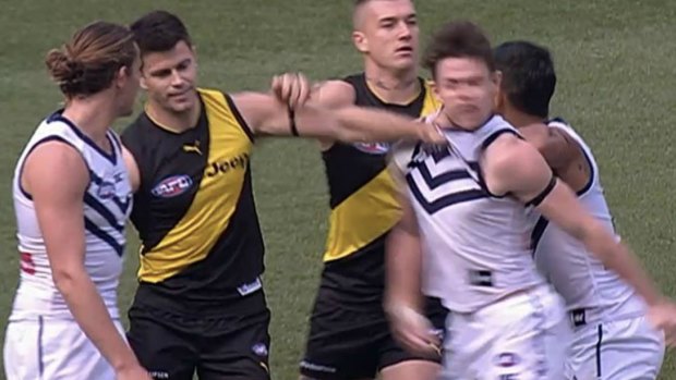 Tigers captain Trent Cotchin gives Dockers gun Lachie Neale a sneaky jumper punch.