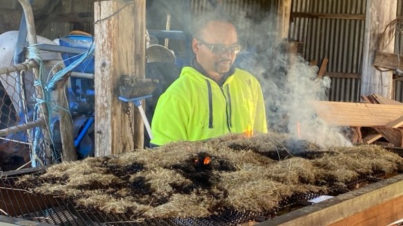 Mamadyang ngalluk or 'dancing grass'. To separate chaff from seed, stalks are laid over a grate with a fire underneath.