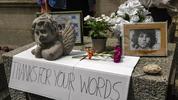 A placard, flowers and pictures are displayed on the tomb of rock singer Jim Morrison at the Pere-Lachaise cemetery in Paris.