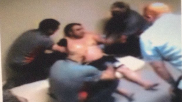 CCTV shows security guards restraining a detainee at Maribyrnong Immigration Detention Centre.