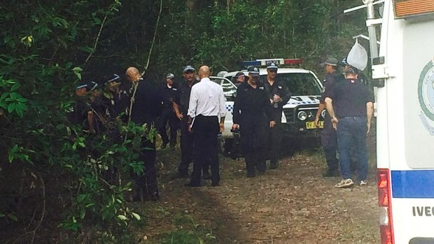 Detective Inspector Jubelin, in the white shirt, is briefed at the scene after officers found bones in the search for William Tyrrell. 

