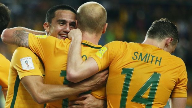 Roos rise: Aaron Mooy, centre, celebrates with Tim Cahill and Brad Smith after scoring.