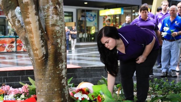 Chaplain Sarah Bennett lays flowers for Cole Miller.