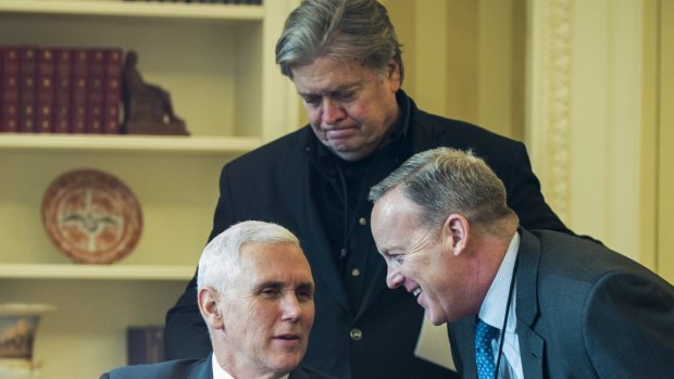 Steve Bannon, chief strategist for US President Donald Trump, stands behind Vice-President Mike Pence and White House press spokesman Sean Spicer in the Oval Office.