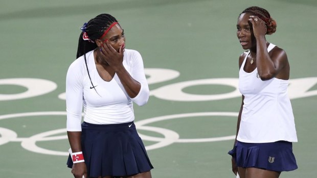 Venus Williams, of the United States, right, talks with her sister Serena after losing a point in a doubles match against Lucie Sarfarova and Barbora Strycova.
